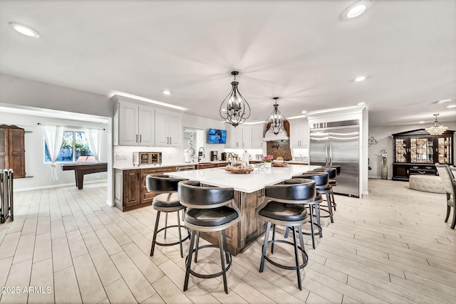 6215 E Surrey Ave, Scottsdale, AZ 85254 - kitchen featuring built in fridge, a chandelier, light countertops, decorative backsplash, and recessed lighting