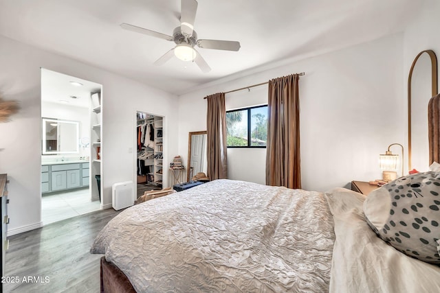 6215 E Surrey Ave, Scottsdale, AZ 85254 - bedroom featuring wood finished floors, a spacious closet, a closet, ensuite bath, and ceiling fan