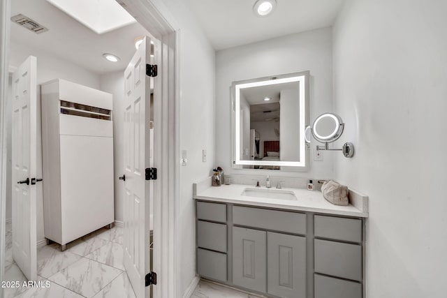 6215 E Surrey Ave, Scottsdale, AZ 85254 - bathroom featuring marble look tiles, vanity, and recessed lighting