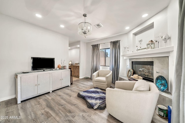 6215 E Surrey Ave, Scottsdale, AZ 85254 - living area with light wood finished floors, a fireplace, a chandelier, and recessed lighting