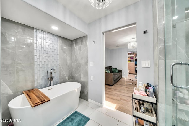 6215 E Surrey Ave, Scottsdale, AZ 85254 - bathroom with a chandelier, tile walls, tile patterned floors, a freestanding bath, and a stall shower