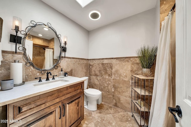 6215 E Surrey Ave, Scottsdale, AZ 85254 - bathroom with tile walls, vanity, and wainscoting
