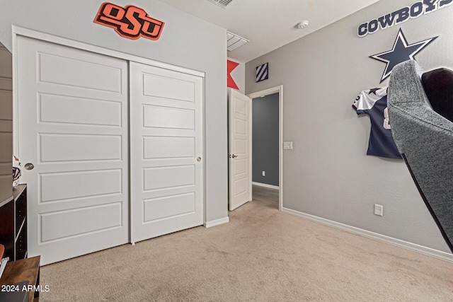 unfurnished bedroom featuring a closet and light carpet