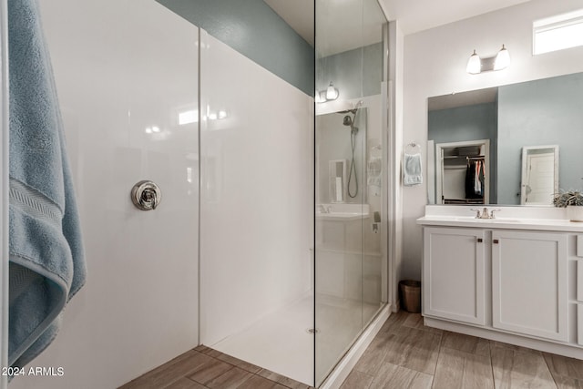 bathroom featuring walk in shower and vanity