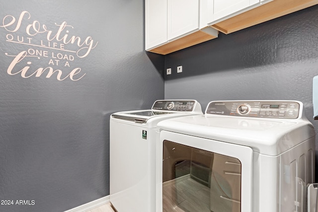 washroom with independent washer and dryer, cabinets, and hardwood / wood-style floors