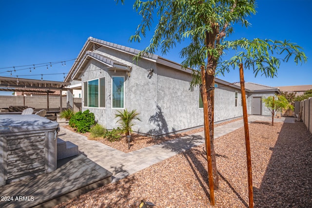 view of property exterior with a patio and a pergola