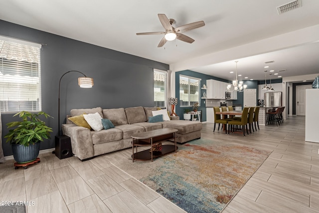 living room featuring ceiling fan with notable chandelier