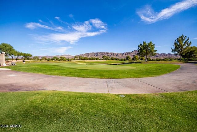 surrounding community with a mountain view and a lawn