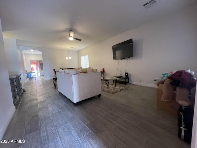 living room featuring dark hardwood / wood-style flooring and ceiling fan with notable chandelier