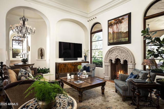 living area featuring a warm lit fireplace and crown molding