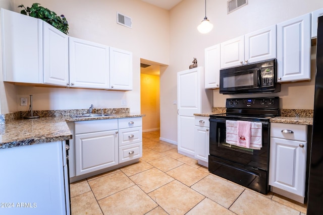 kitchen with white cabinets, hanging light fixtures, a high ceiling, and black appliances