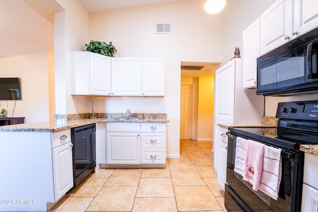 kitchen featuring white cabinets, lofted ceiling, and black appliances