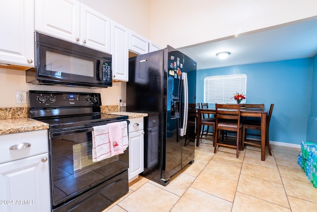 kitchen featuring black appliances, light tile patterned floors, light stone counters, and white cabinets