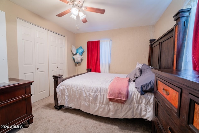 bedroom featuring a closet, ceiling fan, and light colored carpet