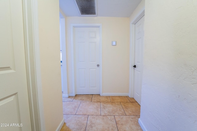 hall with light tile patterned floors