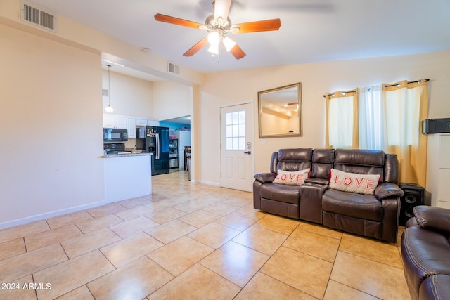 tiled living room featuring ceiling fan and vaulted ceiling