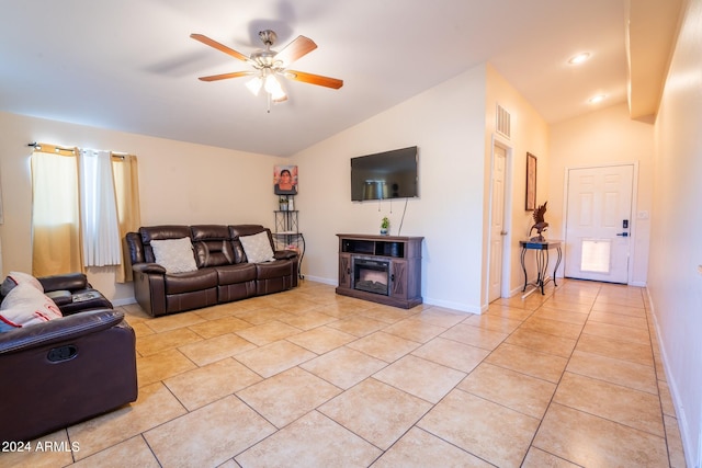 tiled living room featuring ceiling fan, lofted ceiling, and a fireplace