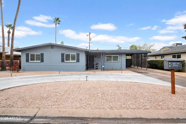 single story home featuring a carport and concrete driveway