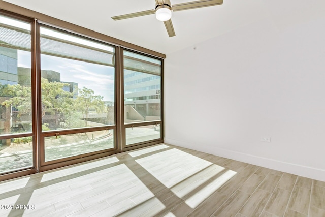 4808 N 24th St Unit 230, Phoenix, AZ 85016 - spare room with light wood-type flooring, a ceiling fan, expansive windows, and baseboards