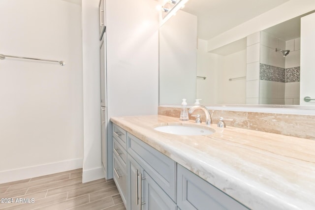 4808 N 24th St Unit 230, Phoenix, AZ 85016 - bathroom with vanity, baseboards, tiled shower, and wood finished floors