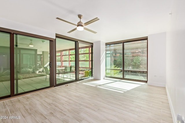4808 N 24th St Unit 230, Phoenix, AZ 85016 - empty room with expansive windows, ceiling fan, wood finished floors, and baseboards