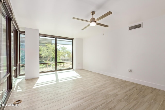4808 N 24th St Unit 230, Phoenix, AZ 85016 - spare room with floor to ceiling windows, a ceiling fan, light wood-type flooring, and baseboards
