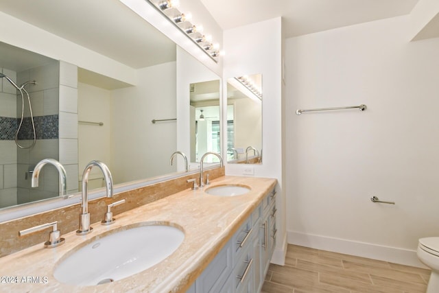 4808 N 24th St Unit 230, Phoenix, AZ 85016 - full bath featuring double vanity, baseboards, wood finished floors, a tile shower, and toilet