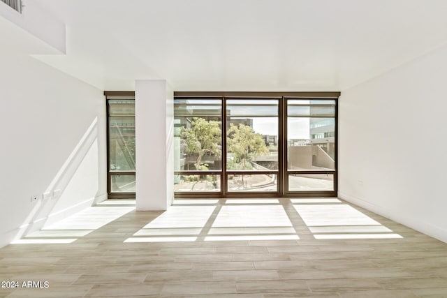 4808 N 24th St Unit 230, Phoenix, AZ 85016 - empty room featuring plenty of natural light, wood finished floors, and floor to ceiling windows