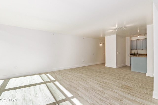 4808 N 24th St Unit 230, Phoenix, AZ 85016 - empty room featuring light wood-style floors, rail lighting, a sink, and baseboards