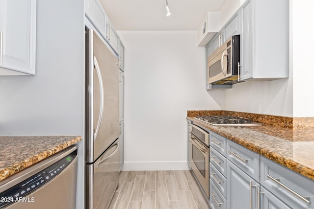 4808 N 24th St Unit 230, Phoenix, AZ 85016 - kitchen featuring appliances with stainless steel finishes, gray cabinets, dark stone counters, baseboards, and light wood-style flooring