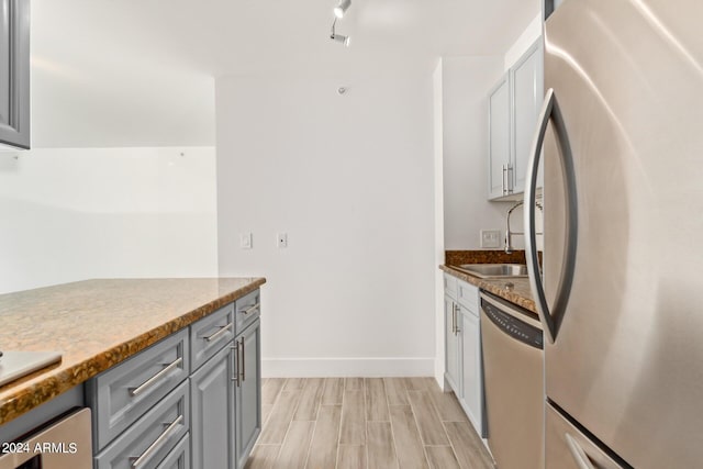 4808 N 24th St Unit 230, Phoenix, AZ 85016 - kitchen with stainless steel appliances, gray cabinets, a sink, baseboards, and light wood-style floors
