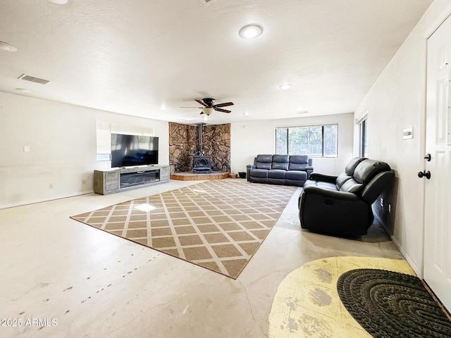 9107 W Fossil Creek Rd, Strawberry, AZ 85544 - living area featuring a wood stove, concrete flooring, and ceiling fan