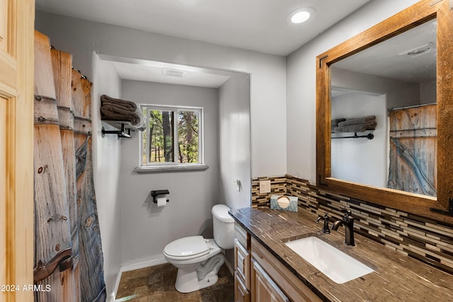 bathroom featuring vanity, decorative backsplash, toilet, and walk in shower