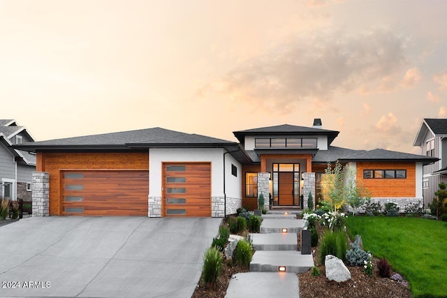 prairie-style house with a garage and a yard