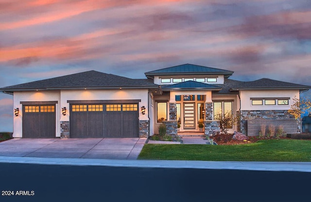 prairie-style home featuring a yard and a garage