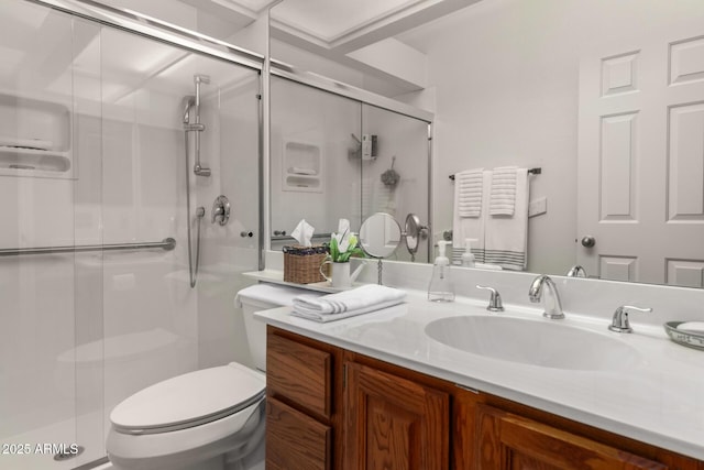 bathroom with toilet, a shower stall, and vanity