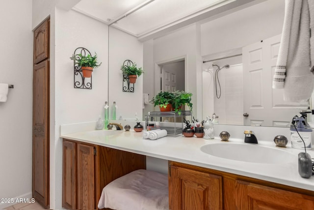 bathroom with double vanity, walk in shower, and a sink