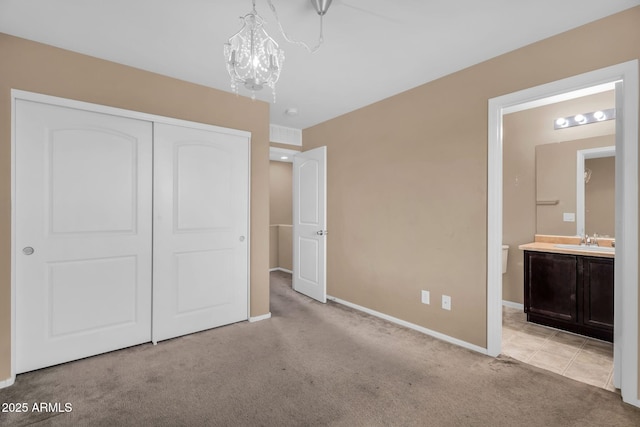 7718 W Pipestone Pl, Phoenix, AZ 85035 - unfurnished bedroom featuring light colored carpet, a sink, a closet, baseboards, and a chandelier