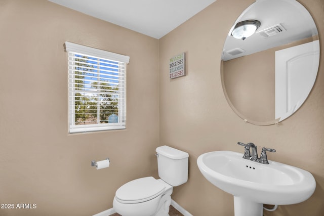 7718 W Pipestone Pl, Phoenix, AZ 85035 - half bathroom with toilet, baseboards, and a sink