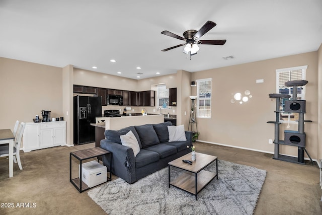 7718 W Pipestone Pl, Phoenix, AZ 85035 - carpeted living room featuring ceiling fan, baseboards, recessed lighting, and a sink
