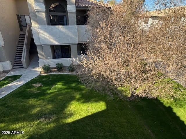 view of home's exterior with a yard, a balcony, and stucco siding