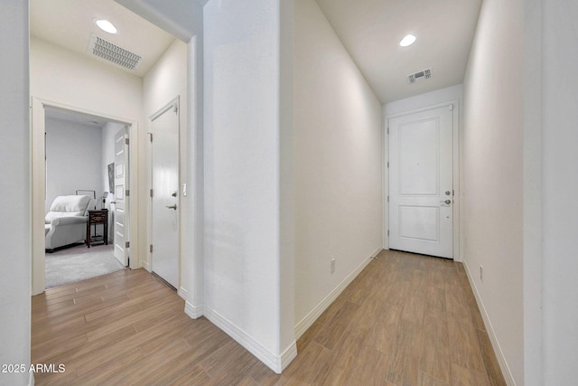 hall with visible vents, recessed lighting, baseboards, and light wood-style floors