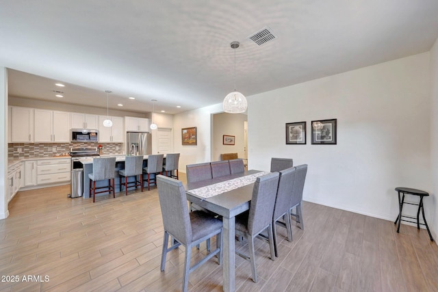 dining room featuring recessed lighting, visible vents, and light wood-type flooring