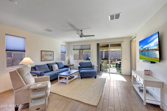 living area with visible vents, a ceiling fan, and wood finished floors