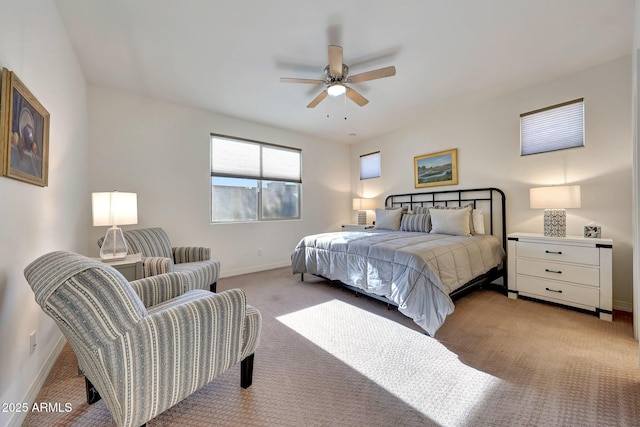 bedroom featuring light colored carpet, a ceiling fan, and baseboards
