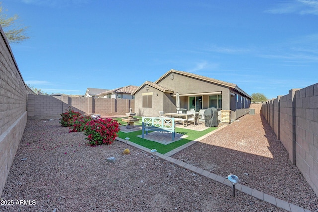 rear view of property with a patio area, a tiled roof, a fenced backyard, and stucco siding