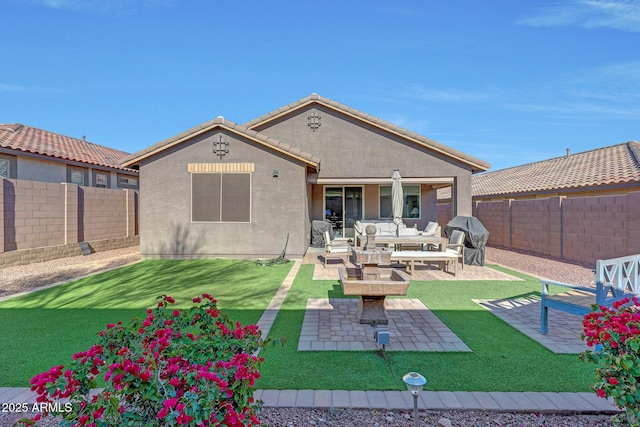back of property with a fenced backyard, stucco siding, a yard, and a patio