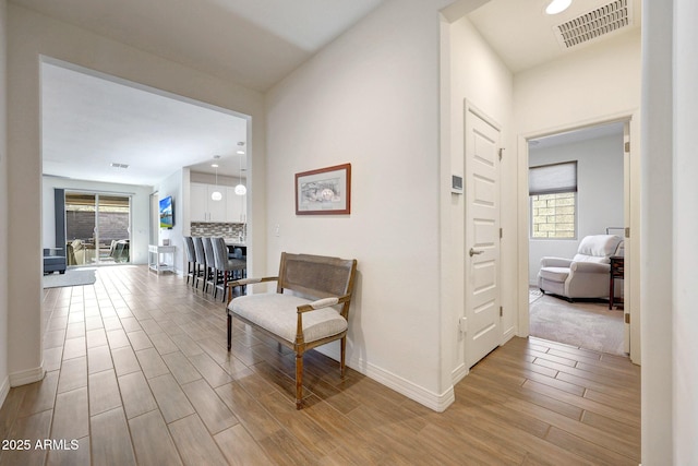 corridor featuring recessed lighting, baseboards, visible vents, and light wood finished floors