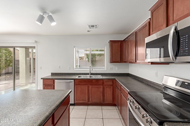 kitchen featuring ceiling fan, appliances with stainless steel finishes, sink, and light tile patterned floors