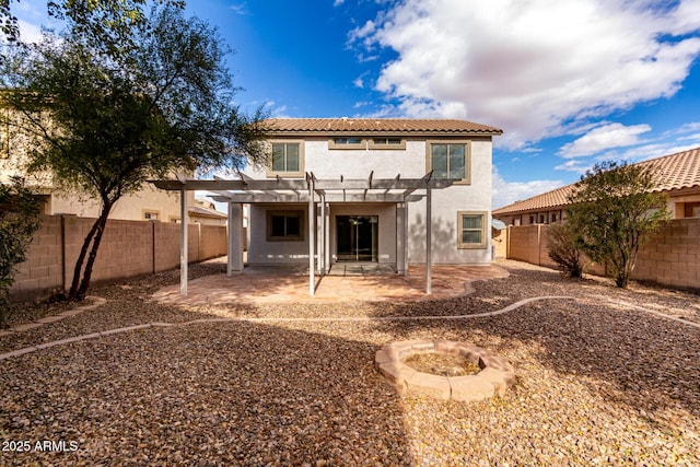 rear view of house with a fire pit, a pergola, and a patio area